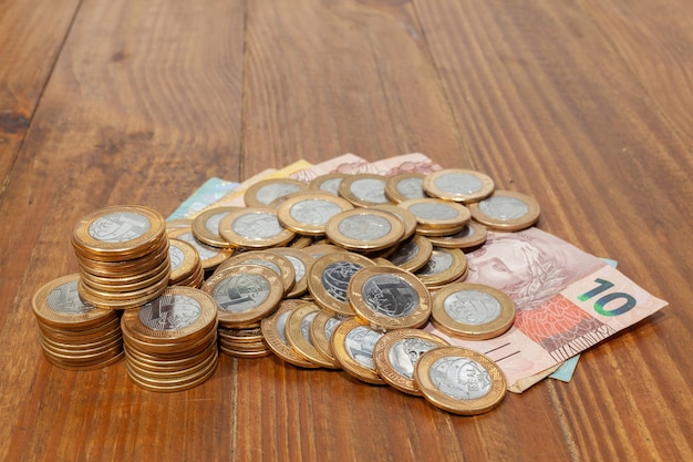 Foto veel braziliaanse munten en bankbiljetten op een houten tafel