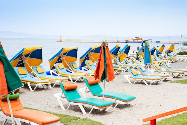 Veel duoton ligbedden met parasols op het zee strand