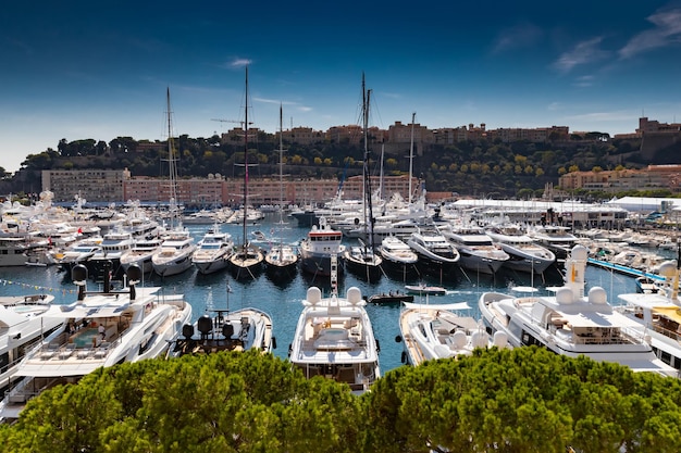 Veel enorme jachten zijn in de haven Hercule van Monaco op zonnige dag Monte Carlo, veel kleine boten zijn op ...