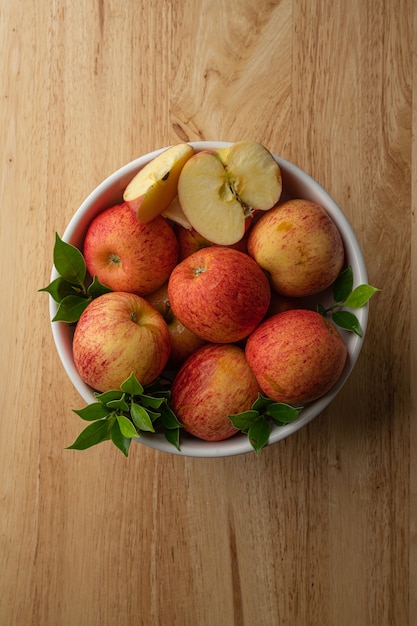 Veel Gala-appels in een witte kom Leg op de houten vloer