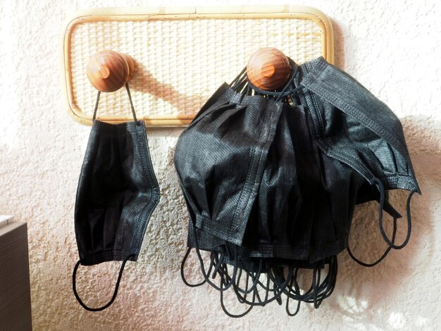 Veel gebruikte zwarte wegwerpmaskers die aan een houten pen hangen Concept van milieuvervuiling