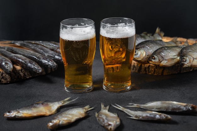 Veel gedroogde gedroogde vis in het assortiment is op een donkere achtergrond aangelegd met smakelijk bier