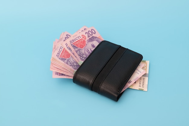 Veel geld in een portemonnee op een blauwe achtergrond. Oekraïense grivna's