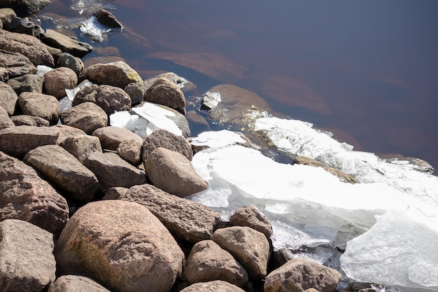 Veel grijsbruine stenen naast het water