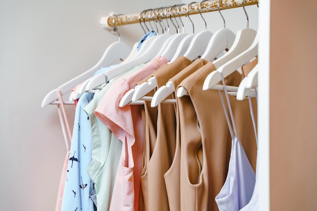 Veel hangers met dameskleding in een kleedkamer of winkel