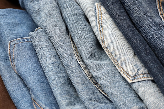 Veel jeans in stapel in garderobekamer Rij broeken denim jeans in kast Concept van kopen, verkopen, winkelen en modieuze kleding