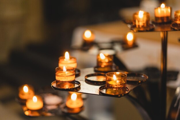Veel kaarsen branden in een kathedraal Religieus ritueel in de kerk Concept voor geloofsspiritualiteit en religie