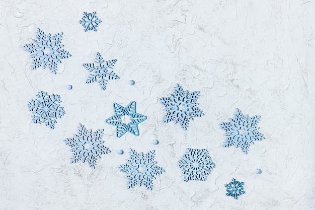 Veel kleine houten decoraties, blauwe sneeuwvlokken op glanzende lichte achtergrond.