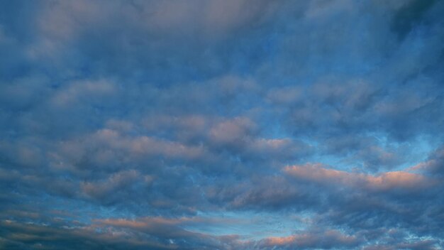 Veel kleine wolken bij zonsondergang opgeblazen pluizige cirrocumulus wolkenlandschap langzaam voorbij helder zonlicht