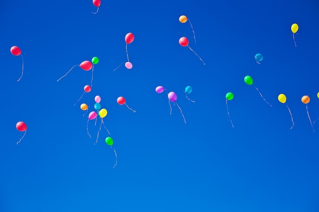 Veel kleurrijke ballonnen vliegen op blauwe lucht