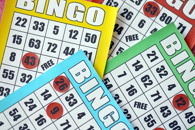 Foto veel kleurrijke bingoborden of speelkaarten voor het winnen van chips klassieke amerikaanse of canadese vijf tot vijf bingokaarten op lichte achtergrond