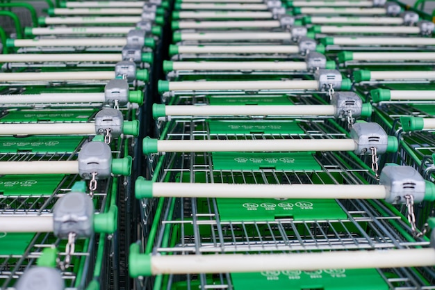 Veel lege groene winkelwagentjes in rij