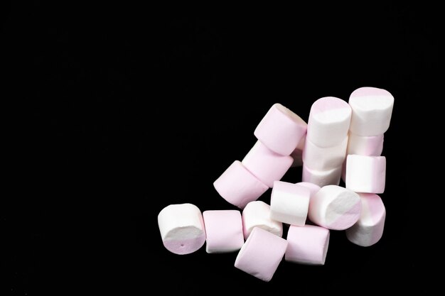 Veel marshmallow snoepjes op een zwarte achtergrond. Detailopname