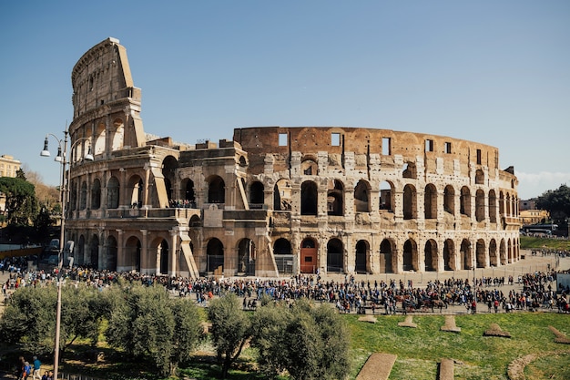 Veel mensen lopen rond in het Colosseum, de oude stad Rome.