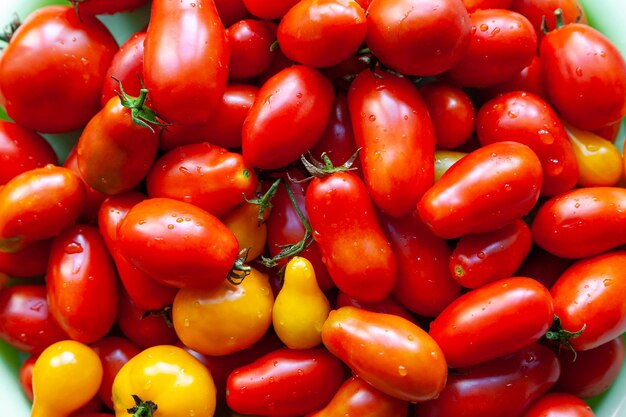 Veel natte tomaat achtergrond Sappige rijpe tomaten met opspattend water op de keukentafel