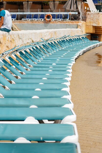 Veel nieuwe mooie blauwe ligstoelen staan op een zonnige dag bij het zwembad in het hotel Prettige vakantievakantie Zomervakantie en toerisme