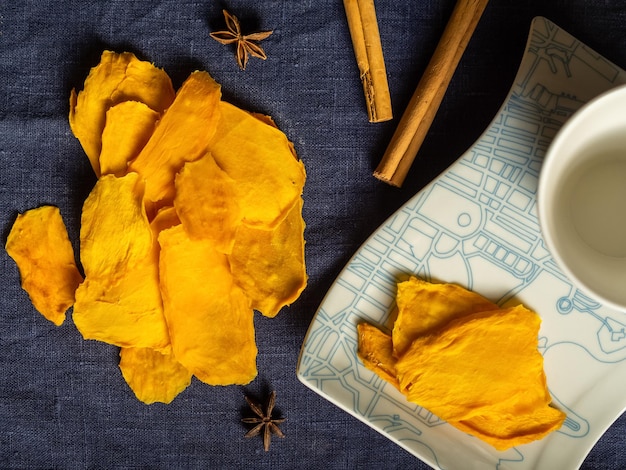 Foto veel oranje gedroogde mango fruit flatlay ligt op een blauwe achtergrond.