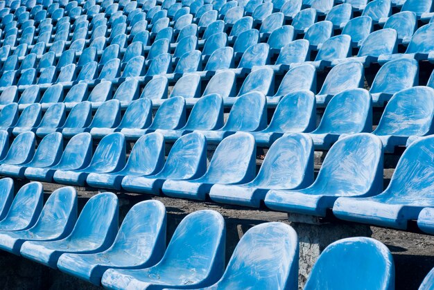 Veel oude blauwe stoelen in een voetbalstadion, voor bezoekers die vervanging of reconstructie nodig hebben