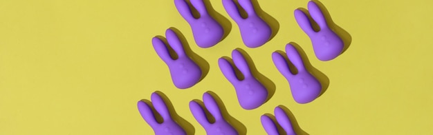 Veel paarse dildo-vibrators voor clitoris op gele achtergrond seksspeeltjes voor volwassenen