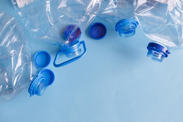 Foto veel plastic lege verkreukelde gebruikte flessen op een blauw achtergrondafval en vervuilingsconcept