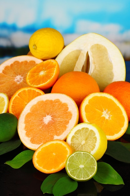 Foto veel rijpe citrusvruchten op zwarte tafel op natuurlijke achtergrond