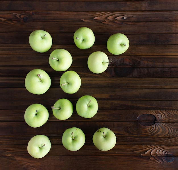 Veel rijpe groene appels op een houten ondergrond.