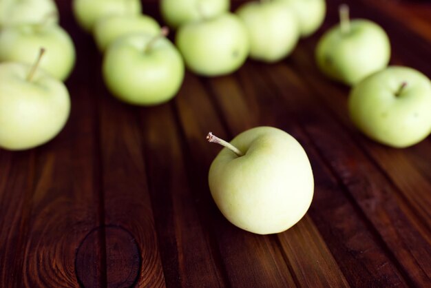 Veel rijpe groene appels op een houten ondergrond.