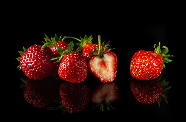 Veel rijpe rode aardbeien op een zwarte achtergrond