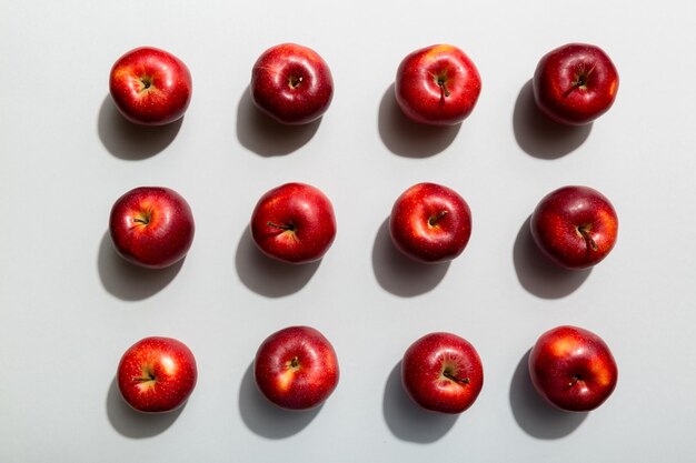 Veel rode appels op gekleurde achtergrond, bovenaanzicht. Herfstpatroon met verse appel boven uitzicht