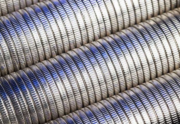 Veel ronde metalen munten van zilverkleurig blauw verlicht