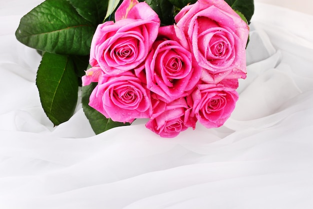 Veel roze rozen in een witte doek geïsoleerd op wit