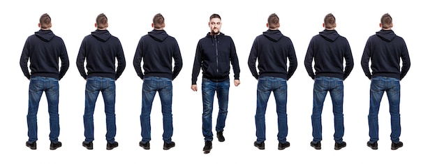 Veel staande mannen in jeans en een blauwe hoodie Achteraanzicht Een knappe man stapt uit hun lijnen vooraanzicht Geïsoleerd op een witte achtergrond panorama-formaat