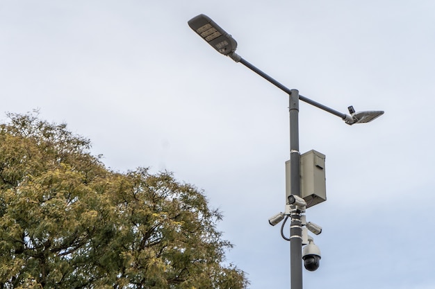 Veel straatbewakingscamera's hangen aan een paal tegen de achtergrond van de straat