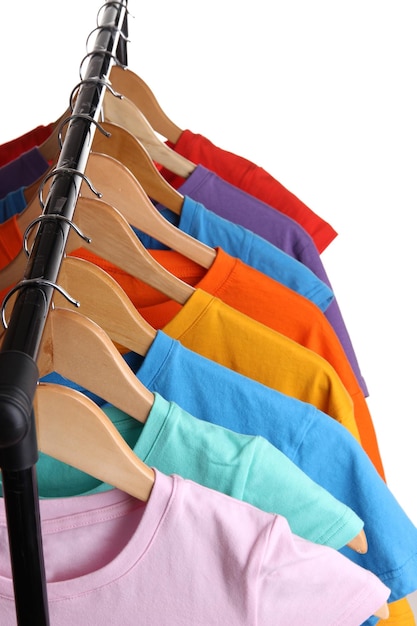 Veel T-shirts op hangers geïsoleerd op wit