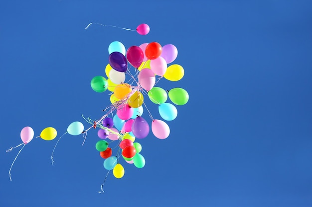 Veel veelkleurige ballonnen vliegen in de blauwe lucht