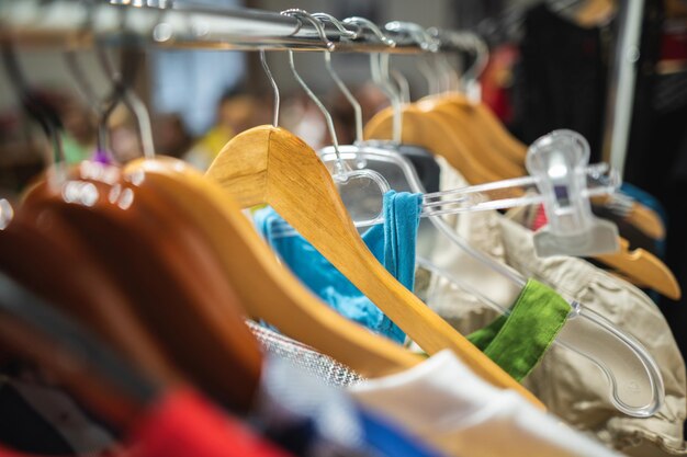 Veel verschillende gekleurde dameskleding op hangers in een winkel