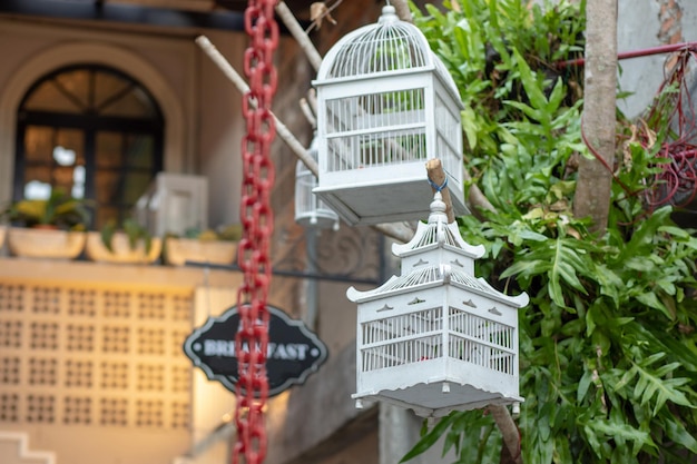 Veel verschillende maten, kleurrijke, houten kooien voor vogels. De winkel voor de verkoop van kooien voor vogels staat helemaal vol met verschillende kleurrijke handgemaakte kooien. Veelkleurige achtergrond. Selectieve aandacht.