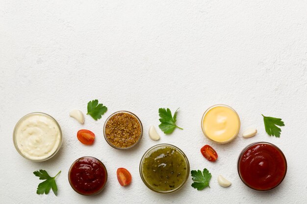 Veel verschillende sauzen en kruiden op tafel liggen plat bovenaanzicht sauzen met kruiden gezond concept