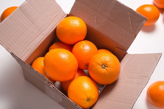 Veel verse citrus sinaasappelen in kartonnen doos, bovenaanzicht