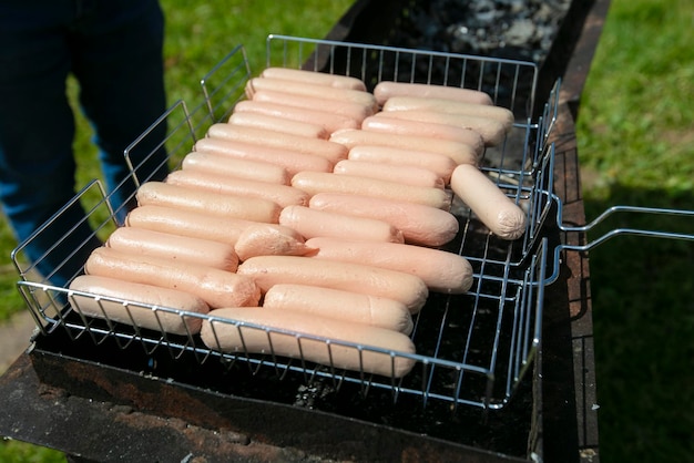 Veel worstjes worden gegrild op een barbecue voor een buffettafel
