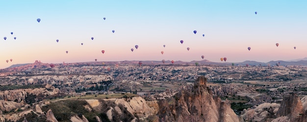 Veelkleurige ballonnen over de vallei van Goreme bij de dageraad