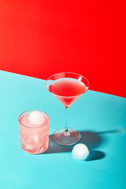 Foto veelkleurige cocktails in glazen van verschillende vormen op een gekleurde achtergrond met harde schaduwen