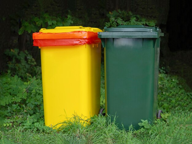 Veelkleurige containers voor gescheiden afvalinzameling op een groene plaats.