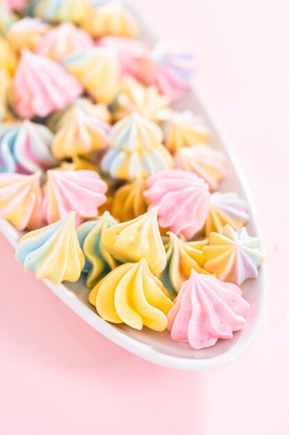 Veelkleurige eenhoorn meringue koekjes op een witte serveerschaal