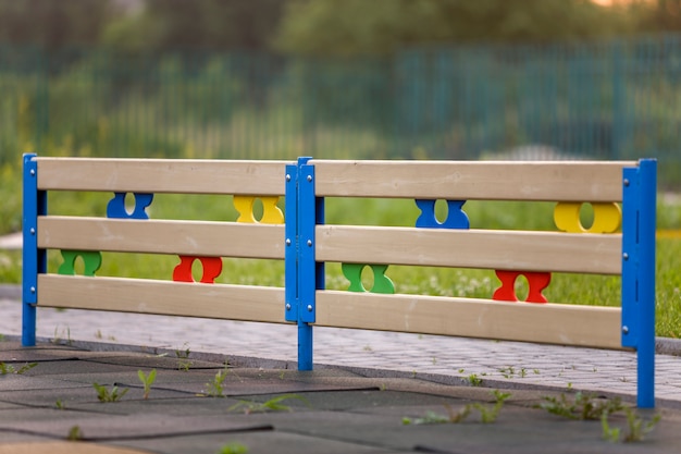 Veelkleurige houten of plastic laag decoratief hek buitenshuis op zonnige zomerdag.