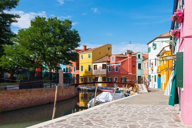 Veelkleurige kleurrijke huizen in Venetië op het eiland Burano Smal kanaal met motorboten langs de huizen Zomer zonnige dag Selectieve focus