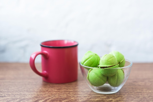 Veelkleurige koekjes in de vorm van noten met gevulde room en kopje koffie op een houten tafel Zelfgemaakte koekjes Kopieer ruimte Lekkere snoepjes