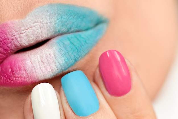 Veelkleurige manicure en lip make-up close-up