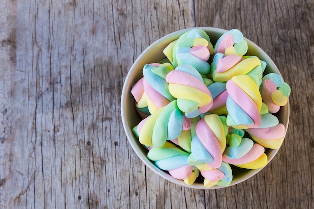 Veelkleurige Marshmallow-draai in een kom op een houten tafel.