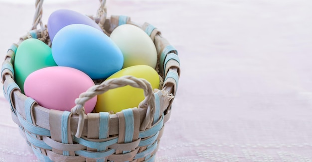 Veelkleurige paaseieren in een rieten mand paaseieren in pastelkleuren